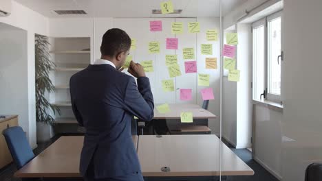 back view of businessman writing on sticky memos