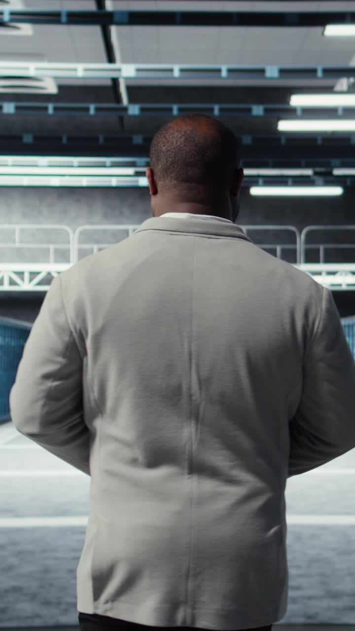 Vertical video System administrator walking in data center with rows of rackmounts