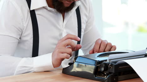 un hombre de negocios hipster usando una máquina de escribir.