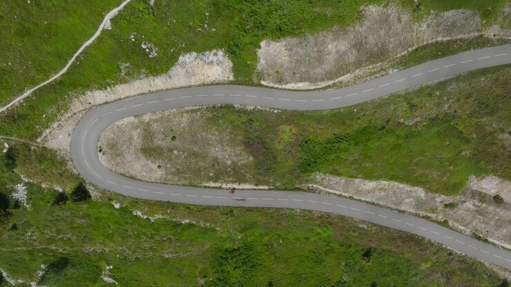 Paesaggi alpini cinematografici catturati lungo l'Alta Via delle Alpi. Scenari montani drammatici, strade tortuose, cime aspre, tempo mutevole e la bellezza naturale delle Alpi europee.