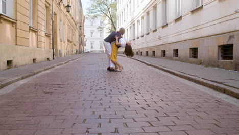 zoom in shot of a happy interracial couple dancing bachata in the old town street 1