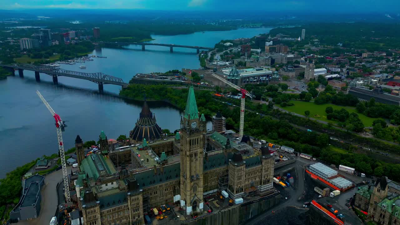 Ottawa'daki Parlamento Tepesi, yaz gününde yemyeşil bitki örtüsü ve büyüleyici ufuk manzarasıyla bölgedeki inşaat vinçlerinin ve çevredeki mülklerin 180 derecelik kuş bakışı hava manzarasını sunuyor.