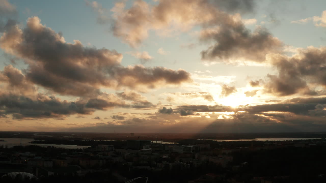 Aerial shot of beautiful nordic town with lakes, and cloudy sky with dramatic sunlight during evening