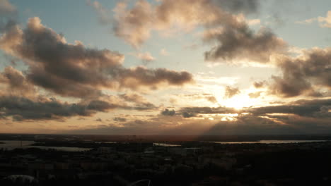 aerial shot of beautiful nordic town with lakes, and cloudy sky with dramatic sunlight during evening