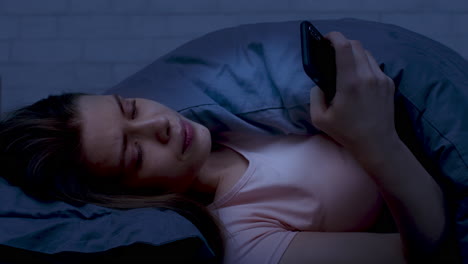 mujer usando el teléfono en la cama por la noche