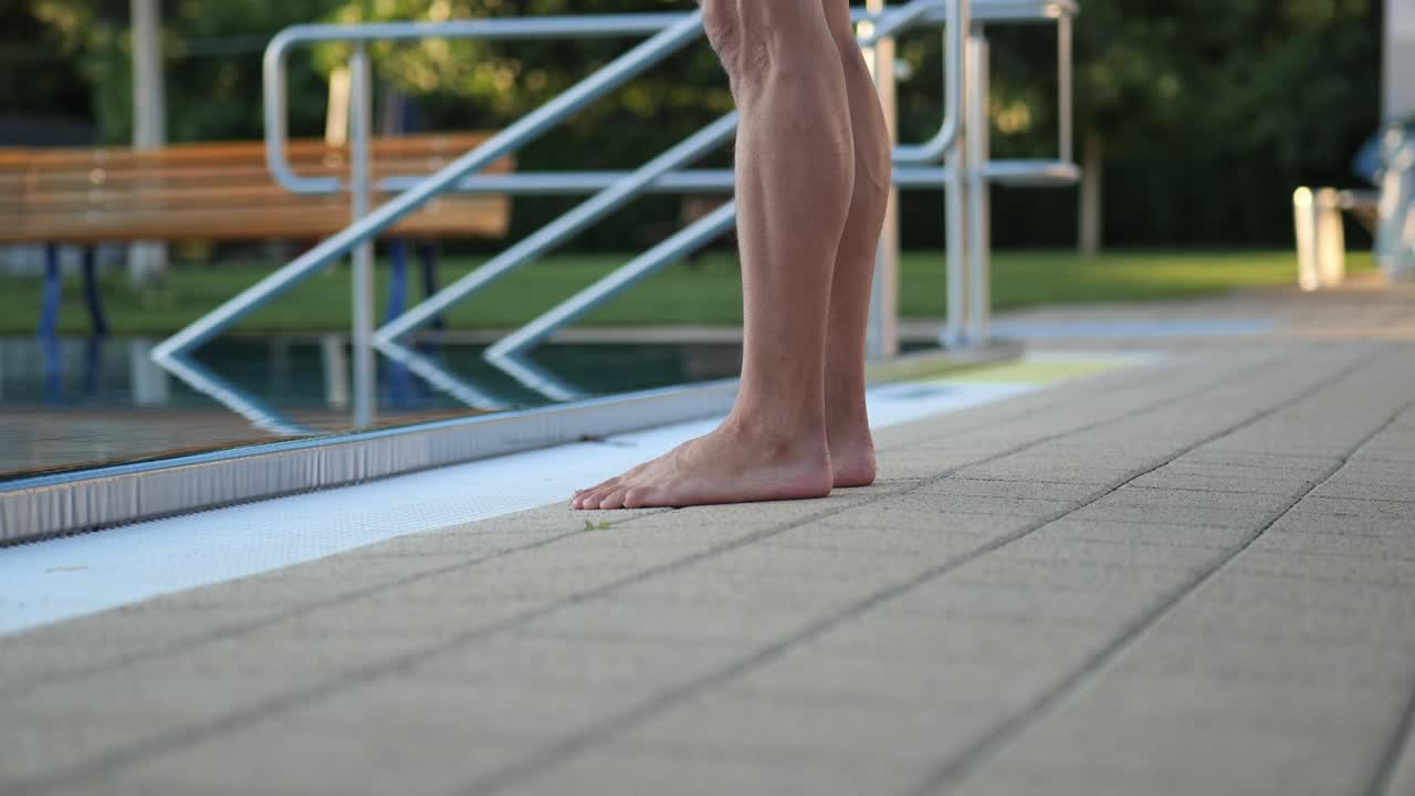 Close up of a swimmer's feet as he walks to the edge of the pool