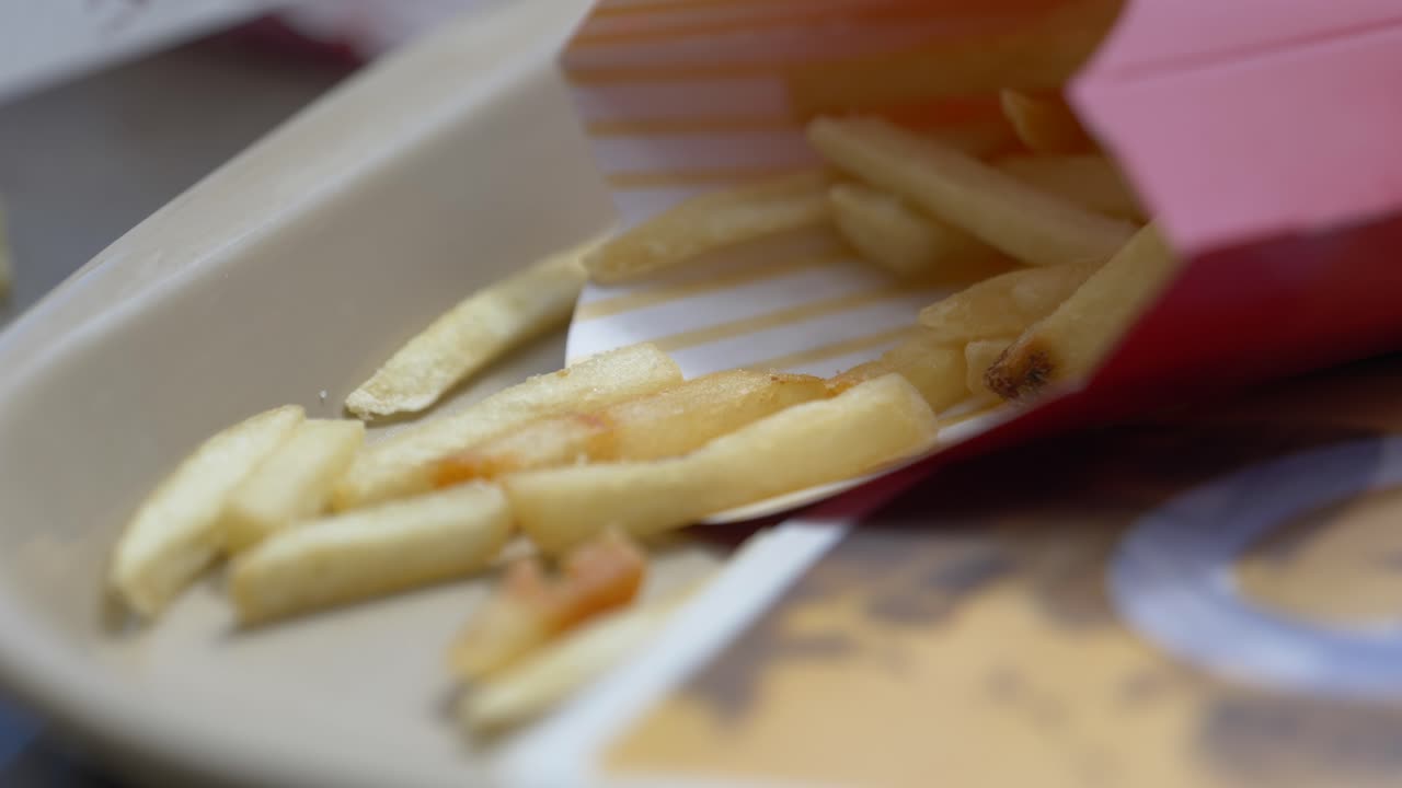 Close up of fries in a container on a tray blowing in the wind ready to eat as a meal for lunch