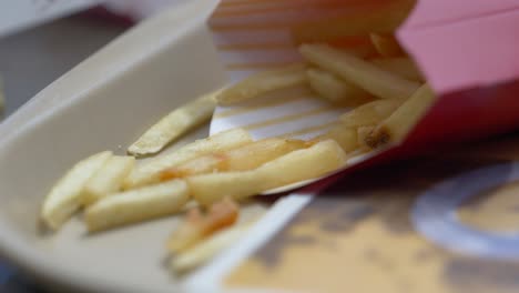 close up of fries in a container on a tray blowing in the wind ready to eat as a meal for lunch