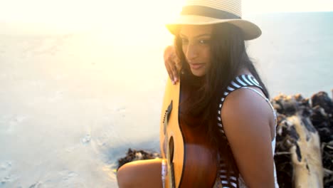 asian indian woman retro dress relaxing with guitar