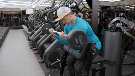 hombre entrenando brazos haciendo scott barbell bíceps rizos en el gimnasio moderno