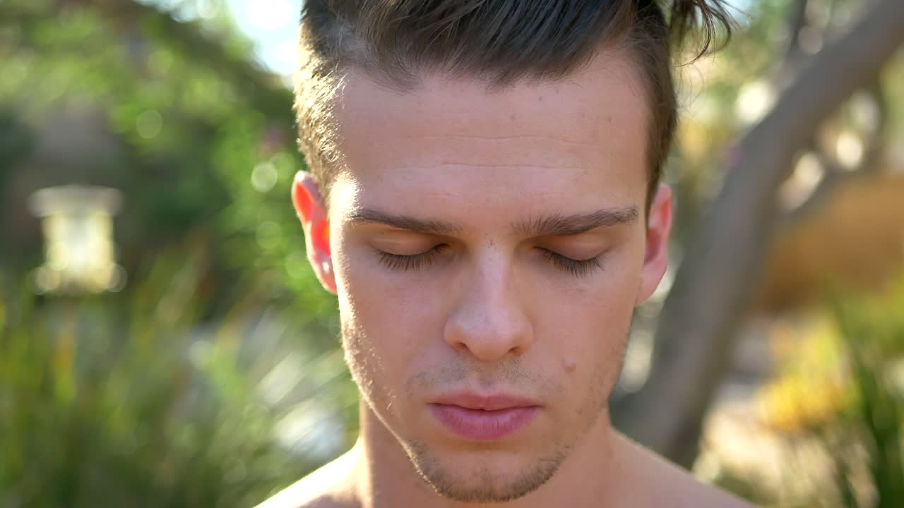 마음챙김, 현재의 자각, 양성을 반영하기 위해 명상에서 눈을 감고 고개를 숙이는 동안 숨을 내쉬는 매력적인 젊은 백인 남자