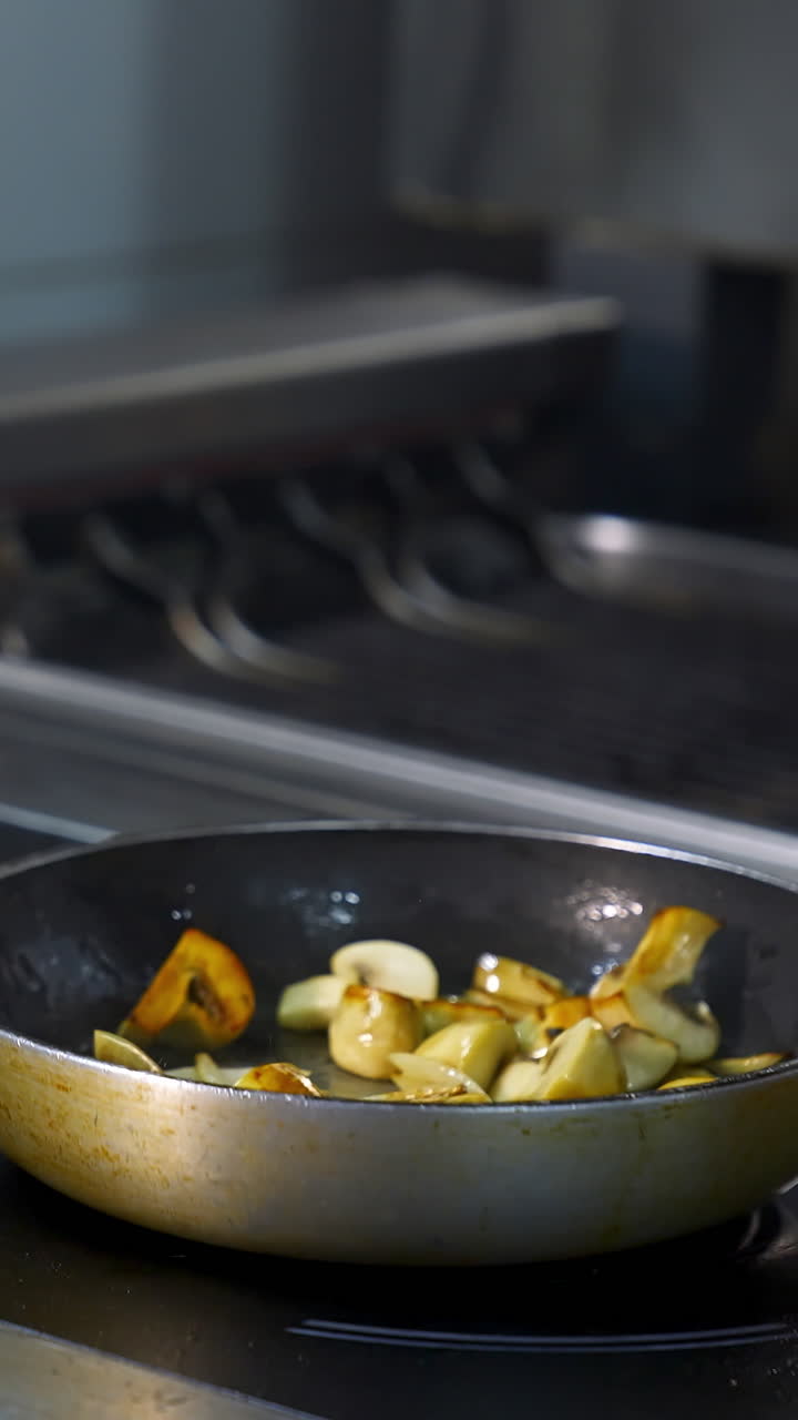 Chef cooks in pan. Chef in restaurant kitchen at stove with pan. Vertical video
