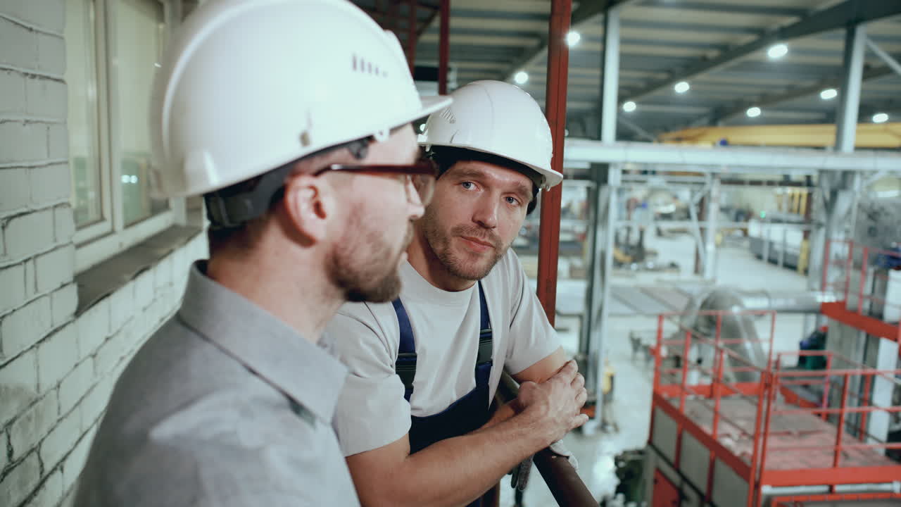 Engineer Supervising and Discussing Factory Operations with Worker