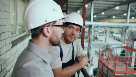 engineer supervising and discussing factory operations with worker