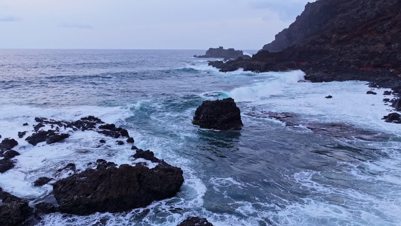 Scure rocce vulcaniche incontrano onde spumeggianti sulla spettacolare costa dell'isola di El Hierro