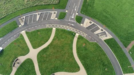 Vista-Aérea-De-Diseño-Circular-Sobre-El-Jardín-Ornamental-Del-Cementerio-Con-Estacionamiento-Alrededor-Del-Exterior