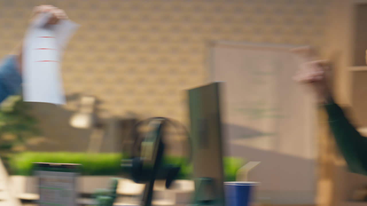 무관심한 남자들이 사무실에서 함께 농담을 하고 있습니다. 남자가 파트너에게 종이를 던지고 있습니다.