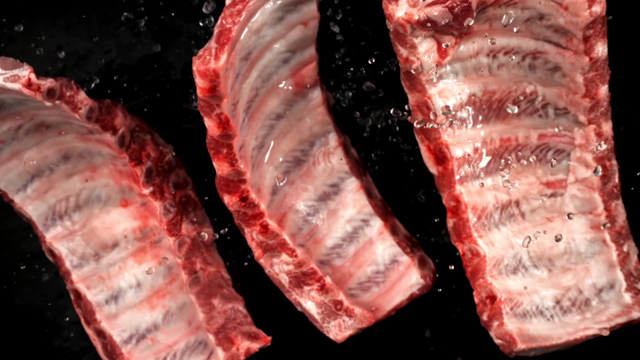 Slow Motion Water Splashing on Raw Pork Ribs