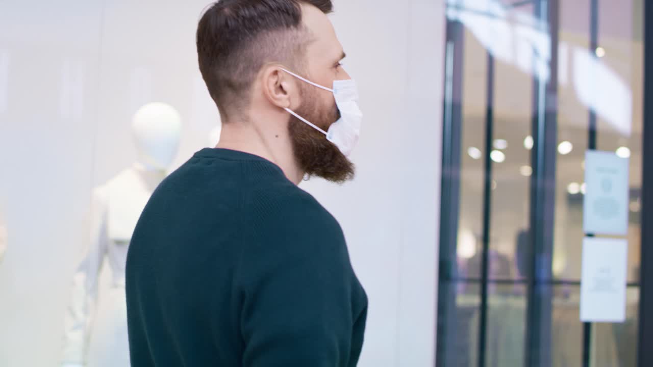 Video of man in protective mask strolling in shopping mall