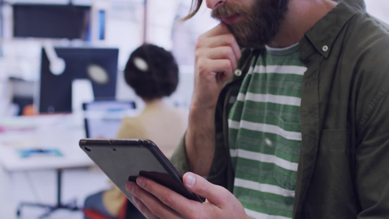 Bearded man studying tablet in open-plan office, animated charts expanding for business analysis