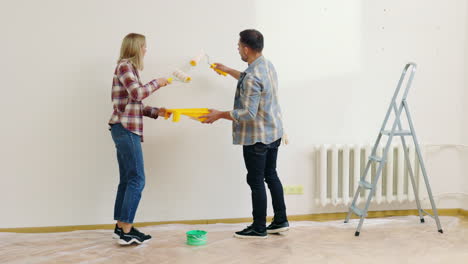 couple painting walls in their home