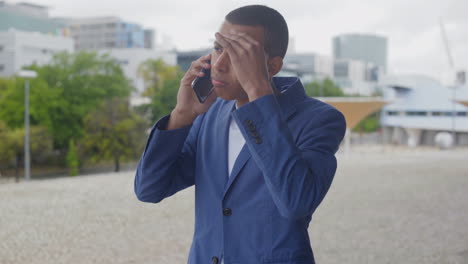 tired african american young man talking on smartphone