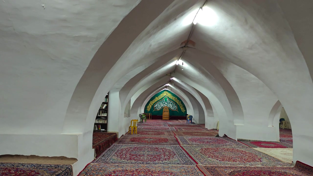 Vista interna di una moschea tradizionale con soffitti a volta e tappeti persiani