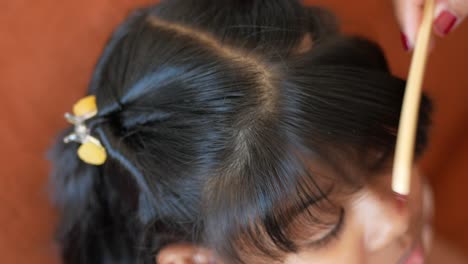 a girl getting her hair combed by a stylist.