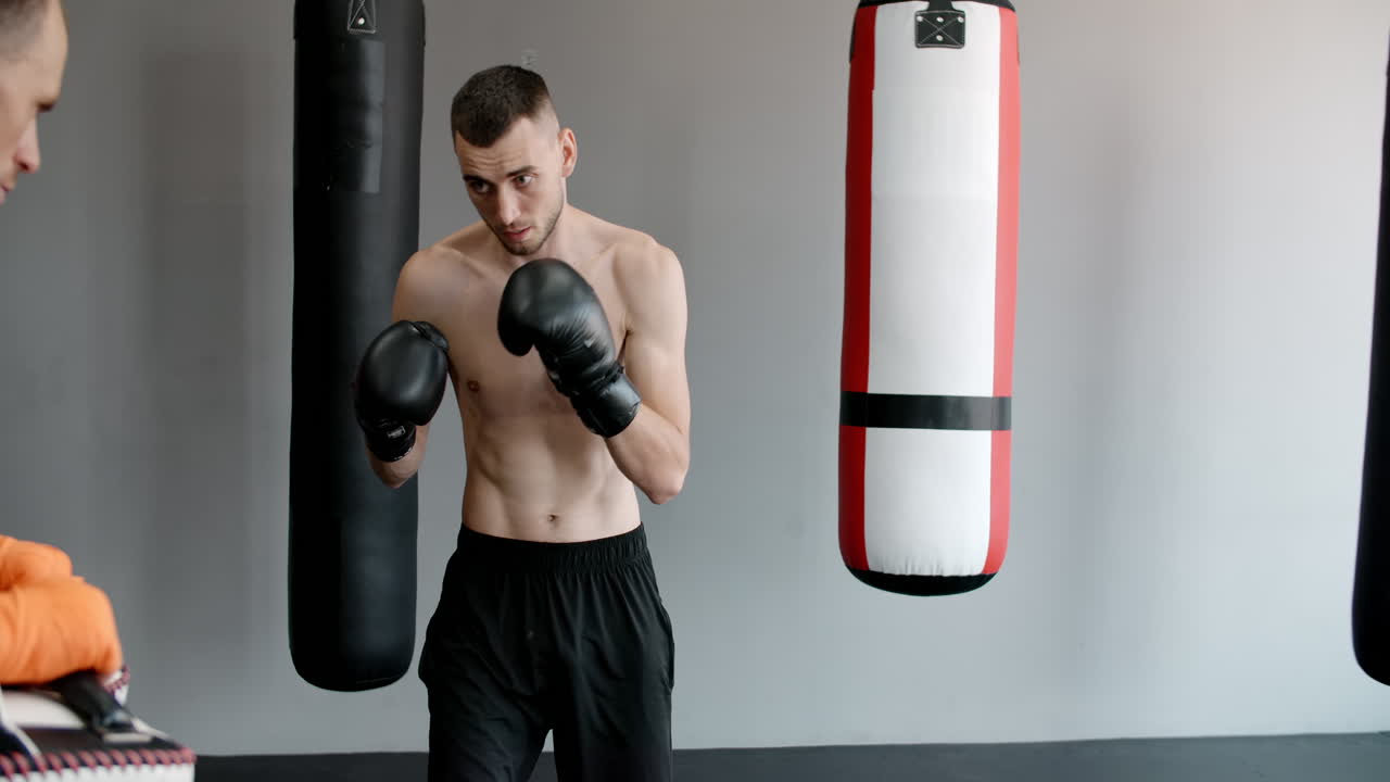 Men practicing Thai boxing in a gym