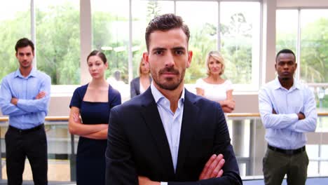 business executives standing with arms crossed at conference center