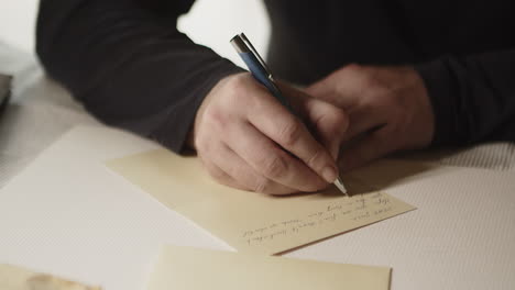 writing letter in hand, pen and paper detail, old school way of communication, front closeup view