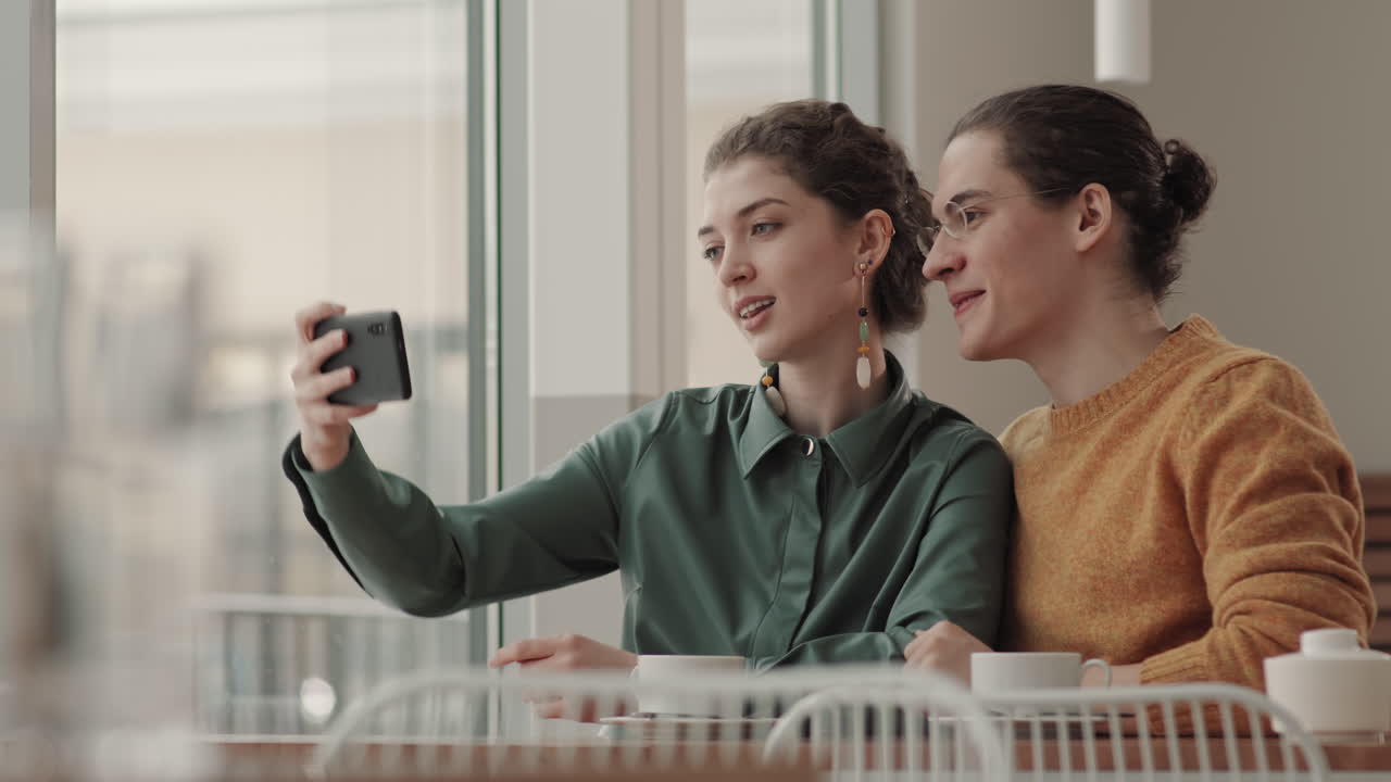 젊은 남녀가 식당에서 셀피를 찍고 있다