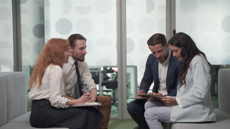 a working group of two businesswomen and two businessmen in the middle of a brainstorming session 1