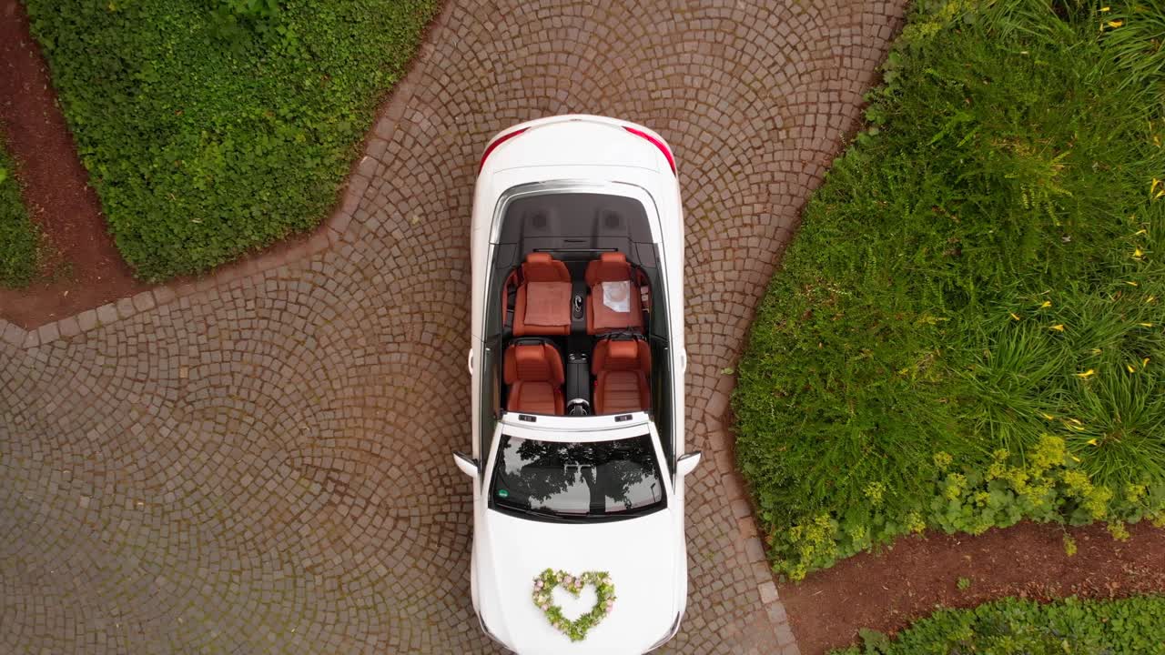 un drone si alza sopra un'auto nuziale che si trova nel parco