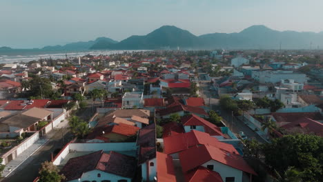 aerial view of a coastal town with beach and mountain backdrop
