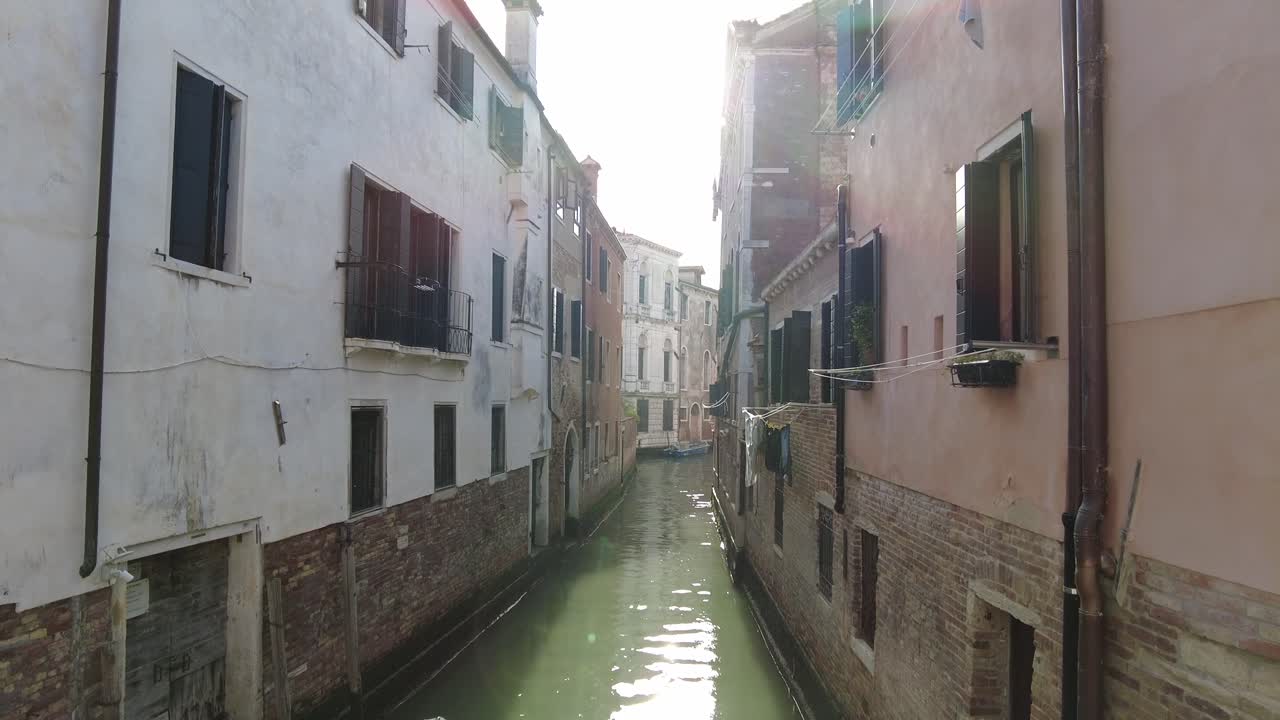 Canale fluviale vuoto costeggiato da vecchi edifici a Venezia, Italia
