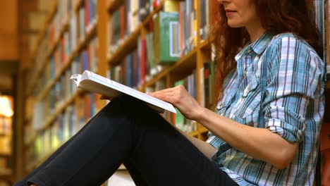 estudiante leyendo un libro de la biblioteca