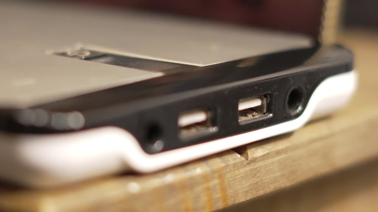 Plugging in USB Cable to Large Portable Battery for Charging Smart Phone on the Go While Travelling or Additional Power for Laptop. Modern IT Computer Technology