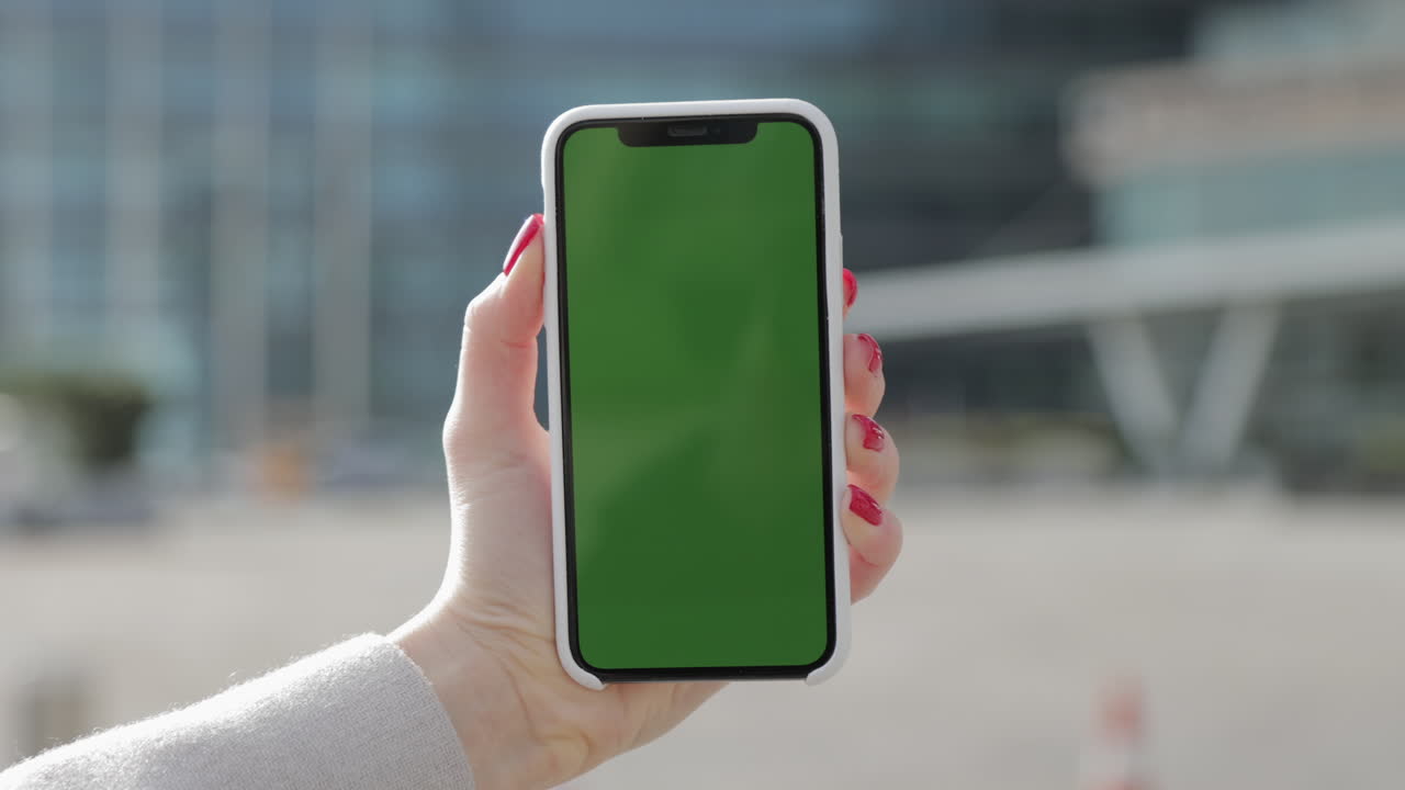 mujer sosteniendo un teléfono inteligente con una pantalla verde