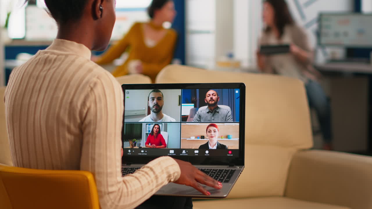 Over the sholder shot of employee talking with partners using video call