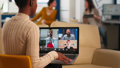 over the sholder shot of employee talking with partners using video call