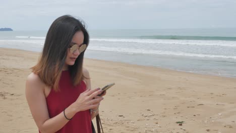 una joven asiática camina por la playa y se relaja mientras está de vacaciones