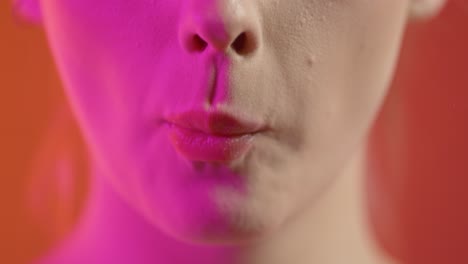 Woman's-Face-and-Mouth,-Eating-and-Chewing-Wafer-Cookie,-Colorful-Studio-Shot