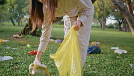 una mujer voluntaria tomando basura en el parque concentrándose en la limpieza ambiental.
