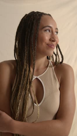 studio portrait shot of young woman with long braided hair recording beauty video 1