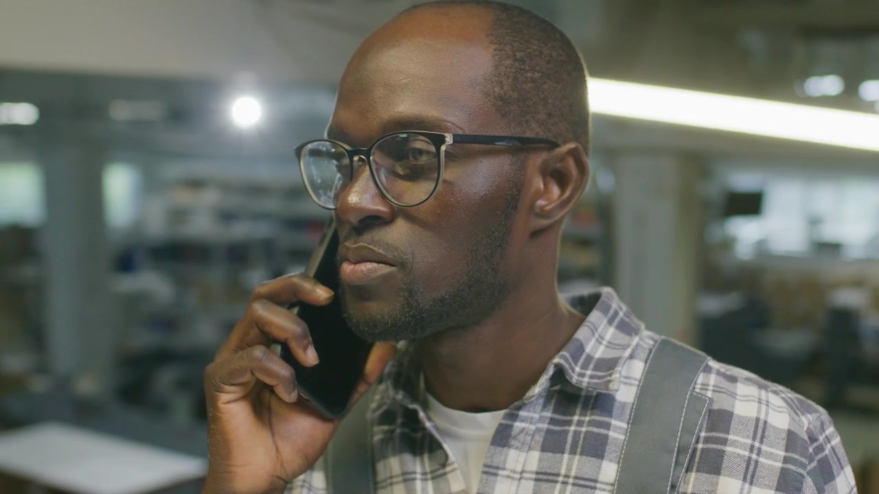Black Printing Factory Technician Speaking on Smartphone at Work