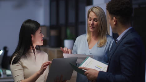 Caucasian-and-Asian-women-discuss-business-with-a-biracial-man-in-an-office