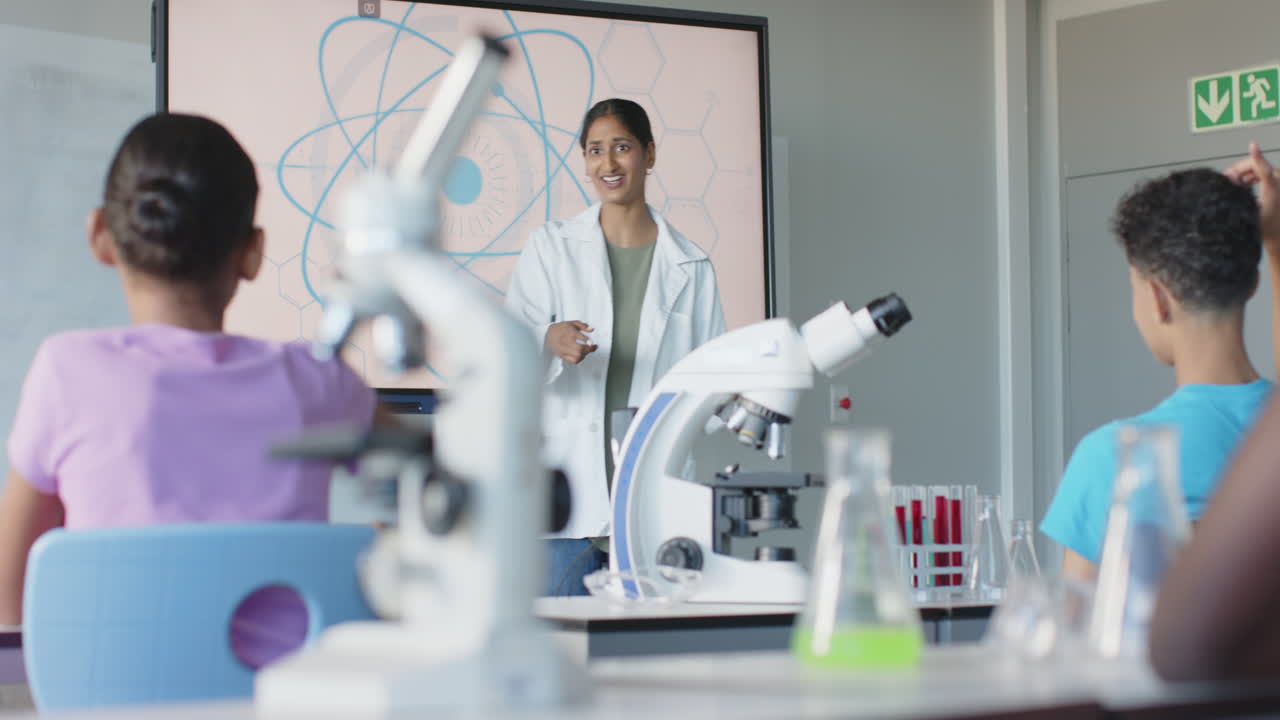 In school, teacher in lab coat engaging students in science classroom