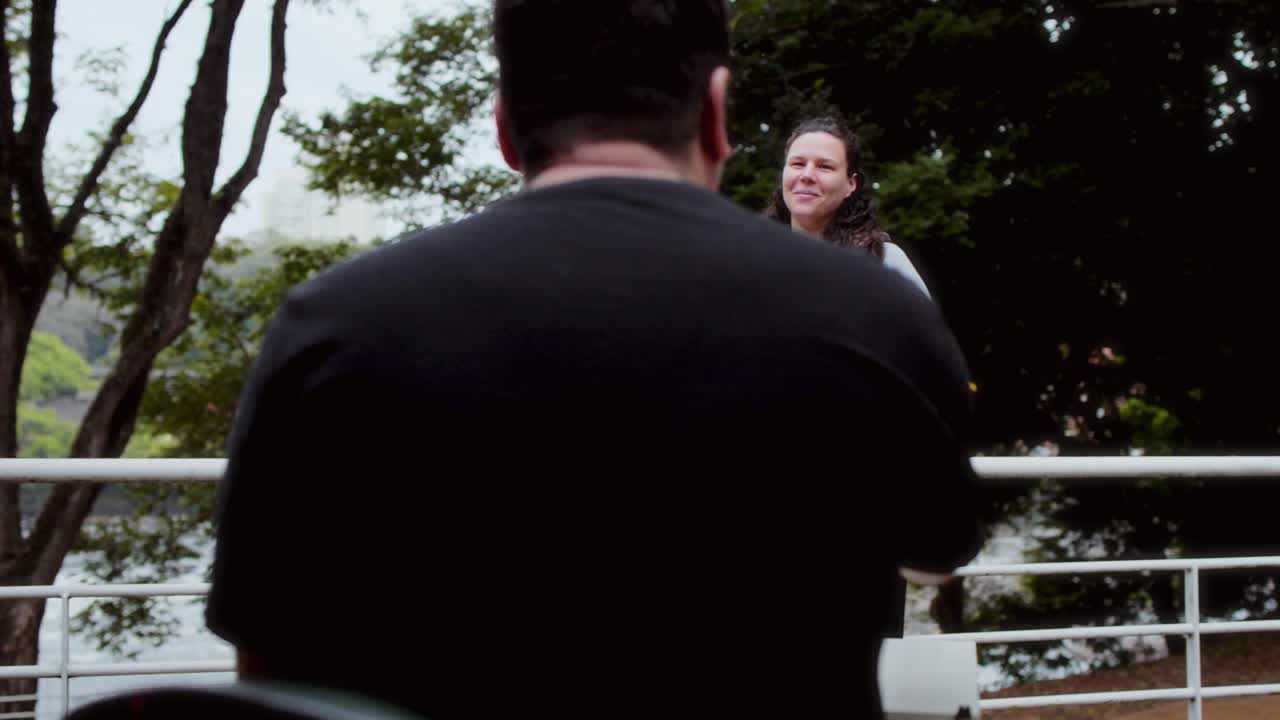 Man painting a woman's portrait outdoors