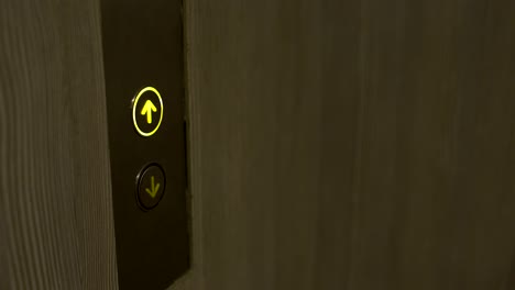 Female hand presses the elevator call button
